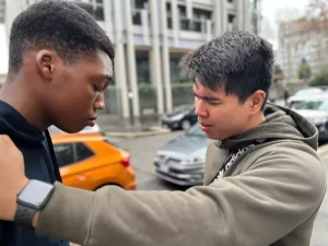 A man praying over other young person to receive Jesus Christ