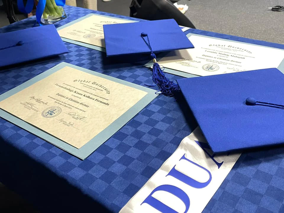 graduation hats and certificates on table at ICCR
