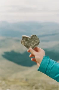 A woman holding a heart shaped stone
