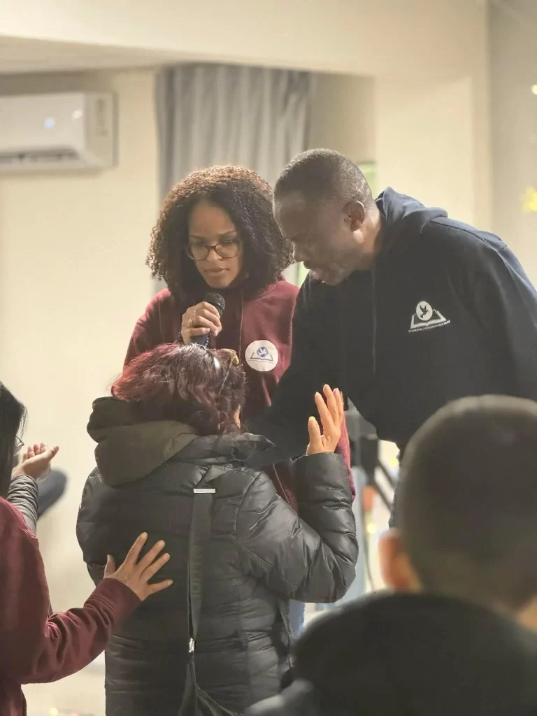 Pastor Lawrence praying over one of the receiver of hope bag